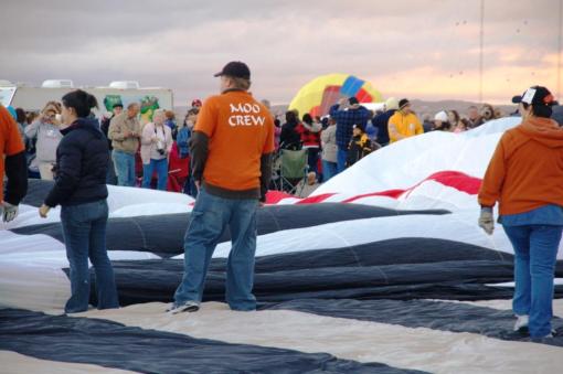 After the weather experts determine if it is a good day for ballooning, balloon crews put their balloons out on tarps. Sun is still not up, but it is light.